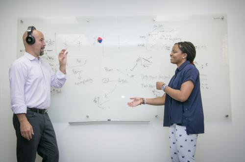 Professor and student talk with whiteboard between them