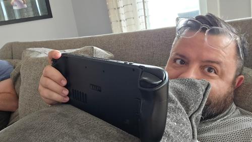 Chris Mager on sofa with pillow and gaming system