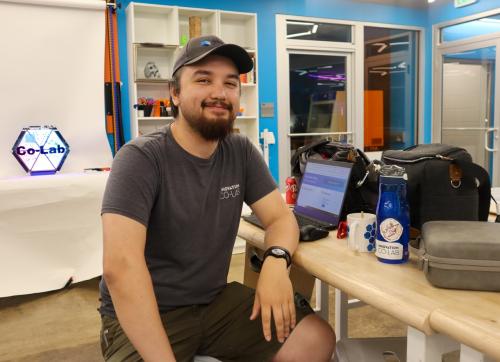 Kevin Thies sits at his workspace in the TEC Studio makerspace