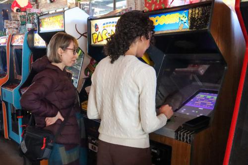 Bendte watches as a colleague plays Frogger at OIT's End-of-Year Celebration.